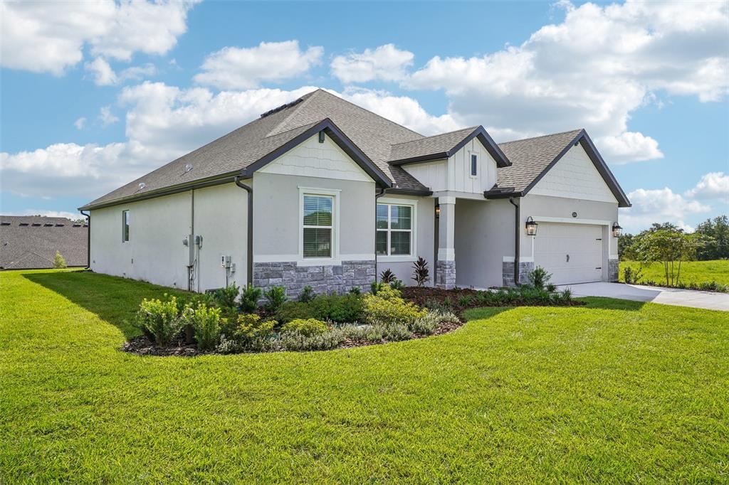 A single-story house with a white exterior, stone accents, and a two-car garage — 36794 SUNDOWNER TRAIL, FRUITLAND PARK, FL