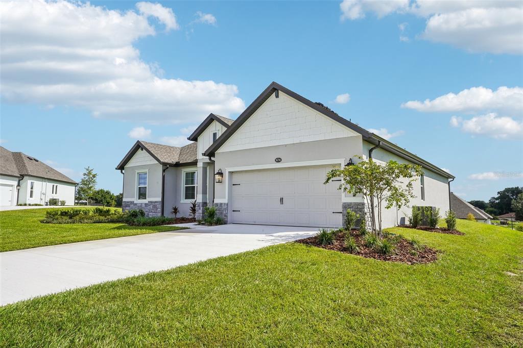 A kitchen island with gray cabinets and white countertops sits in an open-concept living space — 36794 SUNDOWNER TRAIL, FRUITLAND PARK, FL