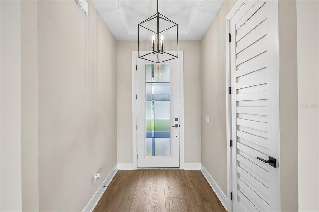 A modern kitchen features white cabinetry, stainless steel appliances, a central island, and wood flooring — 36794 SUNDOWNER TRAIL, FRUITLAND PARK, FL