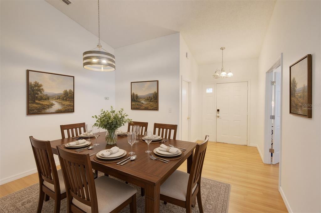 A dining room with a wooden table, six chairs, and three landscape paintings on walls — 538 QUEENSBRIDGE DRIVE, LAKE MARY, FL