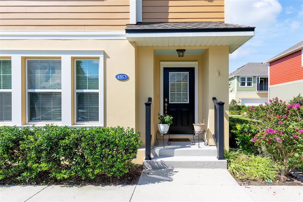 The exterior of a house features a black front door, a small porch, and landscaping — 1357 MILL STREAM LANE, WINTER SPRINGS, FL