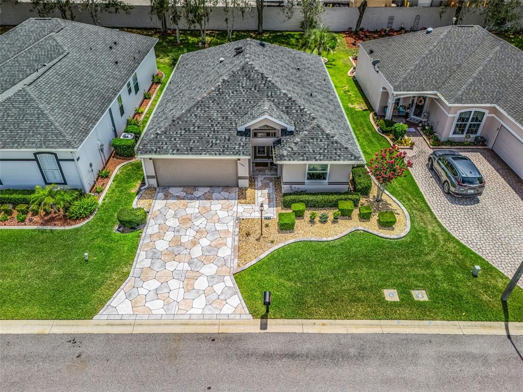 An aerial view shows a suburban house with a patterned driveway and landscaped front yard — 17812 SE 113TH TERRACE, SUMMERFIELD, FL