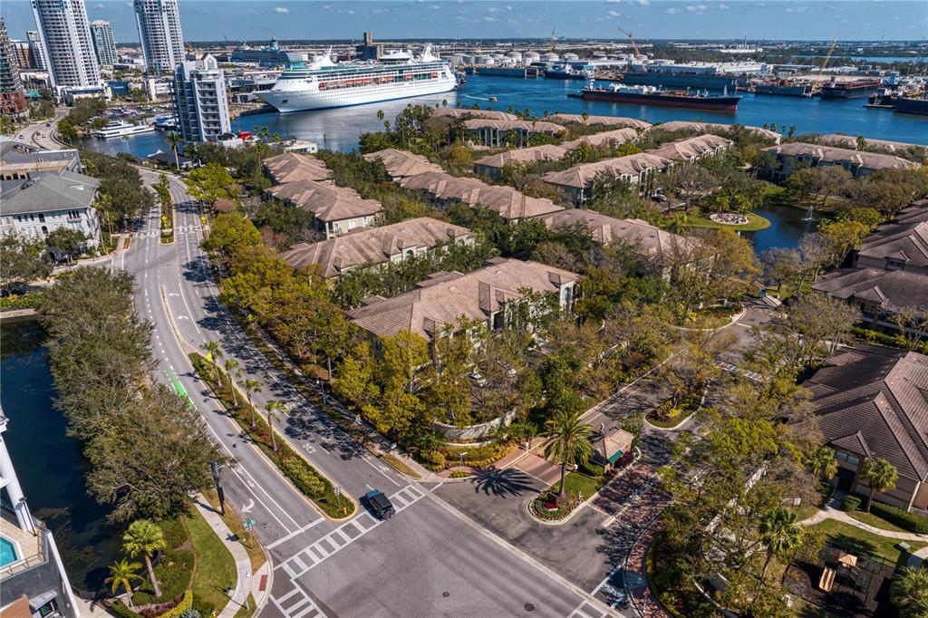 An aerial view of a gated community entrance with a guardhouse, palm tree, and vehicles — 919 NORMANDY TRACE ROAD, TAMPA, FL