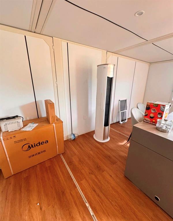 A room with wood-look flooring, white paneled walls, a tower fan, and a Midea box — 3824 STATE ROAD 33, CLERMONT, FL
