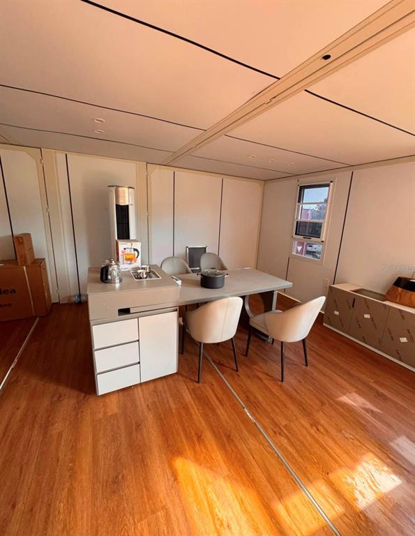 A room with wood-look flooring, a dining table with chairs, and a small kitchen island — 3824 STATE ROAD 33, CLERMONT, FL