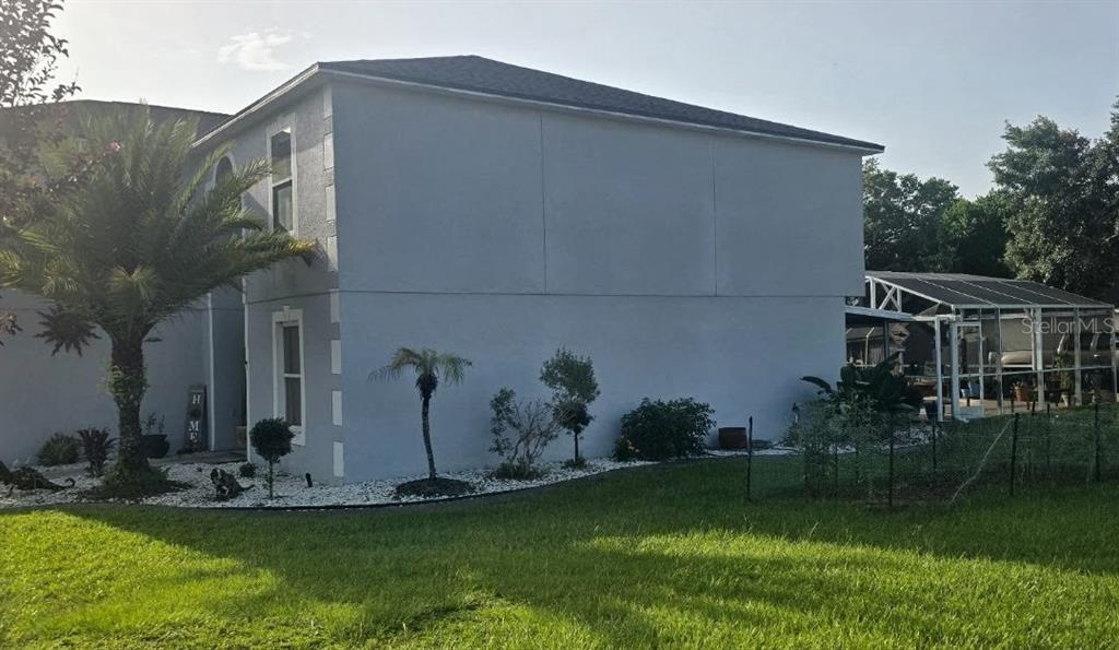 A two-story house with light gray stucco siding, white trim, and a screened-in patio area — 600 BRIARCLIFF ROAD, EUSTIS, FL