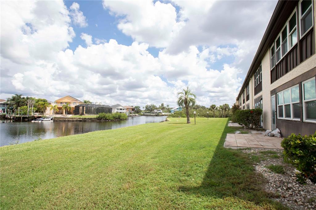 A view of a calm waterway with a palm tree in the foreground — 4609 MARINE PARKWAY UNIT 203, NEW PORT RICHEY, FL