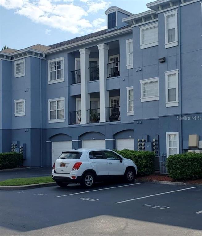 A white SUV is parked in front of a blue multi-story apartment building — 3621 CONROY ROAD UNIT 720, ORLANDO, FL