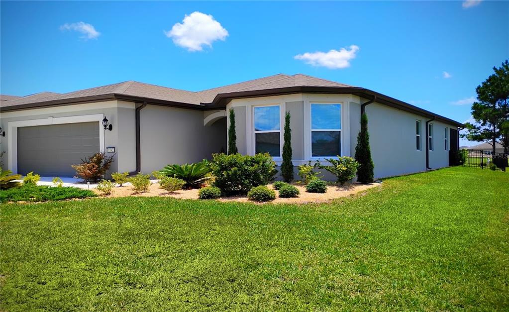A single-story house with a gray exterior, a two-car garage, and a landscaped front yard — 8542 SW 55TH STREET ROAD, OCALA, FL