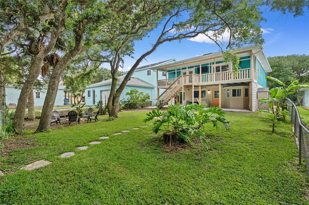 A large wooden deck features built-in planters and mature trees in a residential backyard — 1339 S DAYTONA AVENUE, FLAGLER BEACH, FL