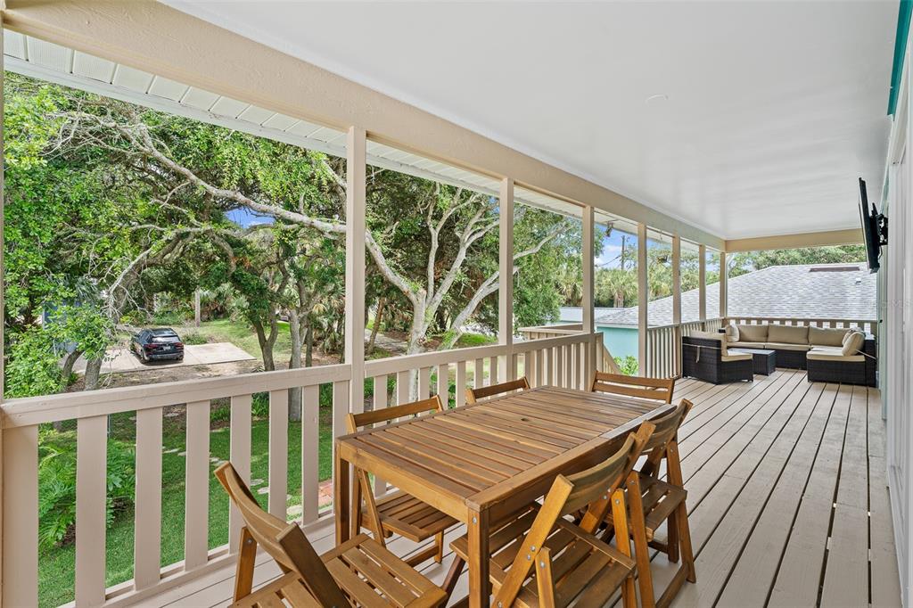 A dining area with a wooden table and chairs sits in front of a living room — 1339 S DAYTONA AVENUE, FLAGLER BEACH, FL