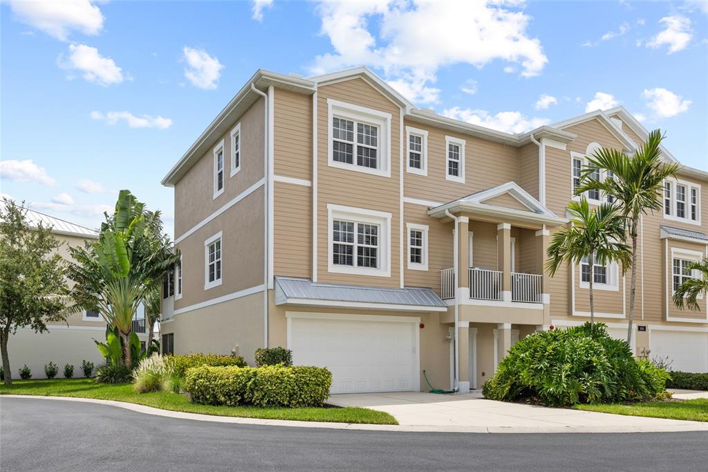 A beige two-story townhouse with a white garage door and a small front balcony — 10311 LANDS END CIRCLE UNIT 16, PLACIDA, FL