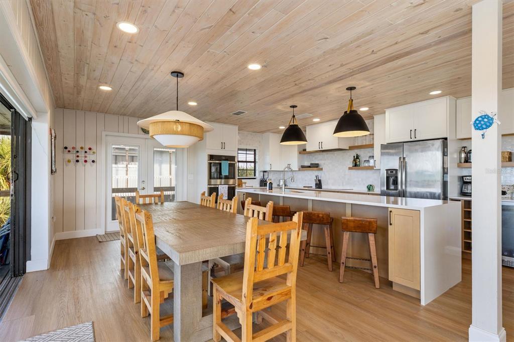 A kitchen and dining area with a wooden ceiling, white cabinets, and a large table — 9498 ALBORADO ROAD, PLACIDA, FL