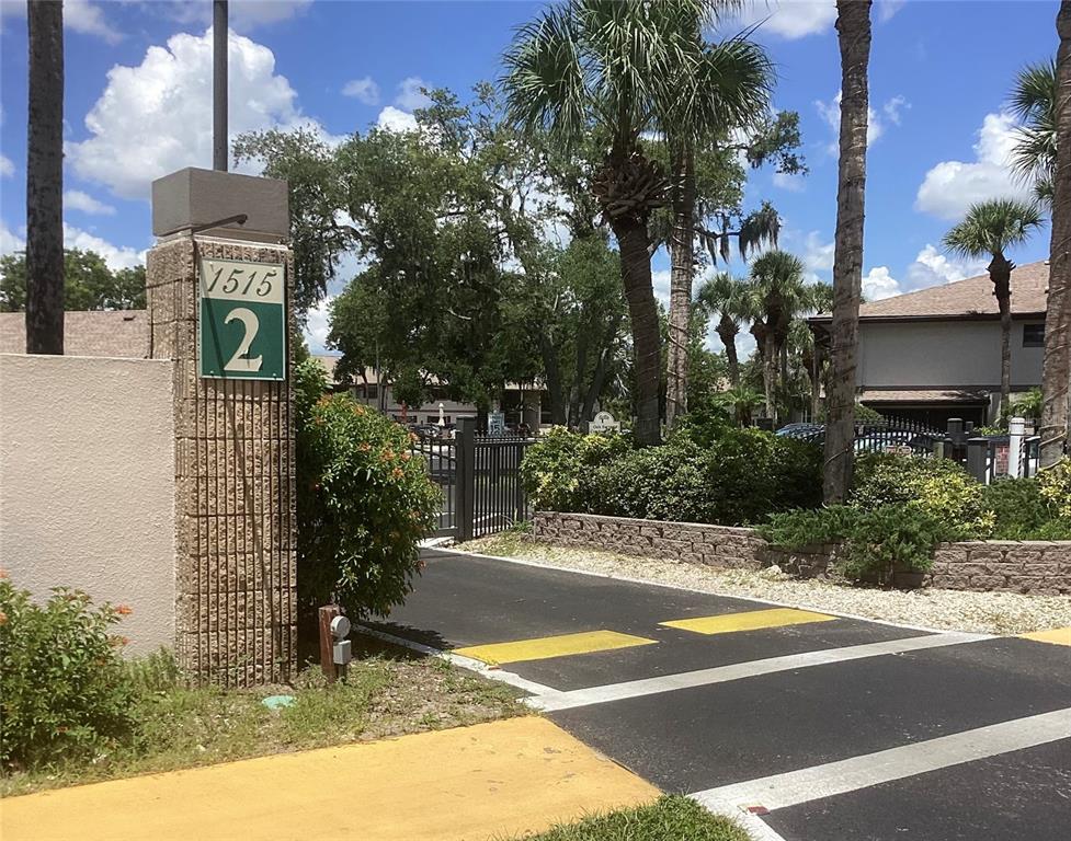 A stone pillar with a sign labeled 1515 2 stands at a gated entrance — 1515 FORREST NELSON BOULEVARD UNIT K106, PORT CHARLOTTE, FL