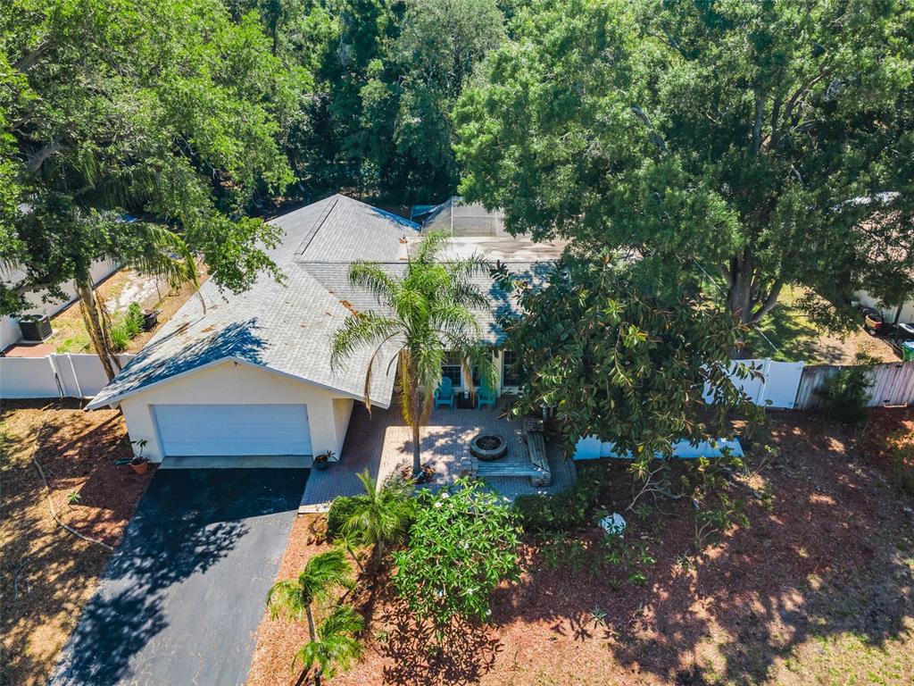 An aerial view shows a single-story house with a garage, driveway, and a landscaped patio — 520 SANDY HOOK ROAD, PALM HARBOR, FL