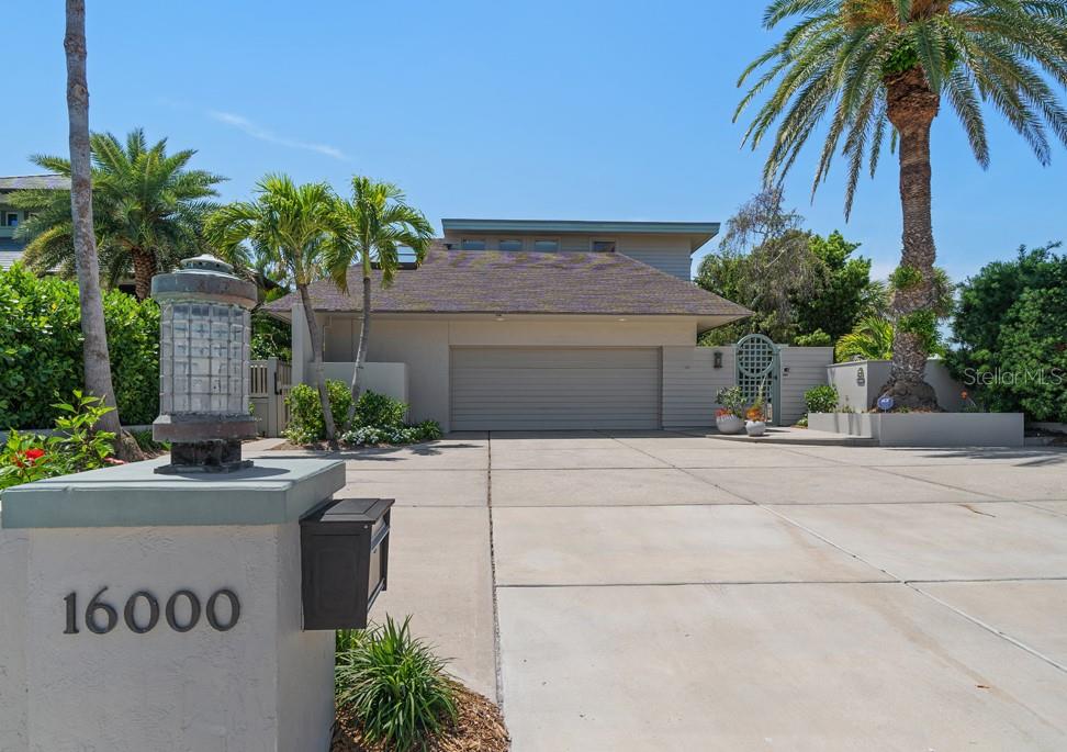 A concrete driveway leads to a two-car garage in front of a modern house — 16000 GULF BOULEVARD, REDINGTON BEACH, FL