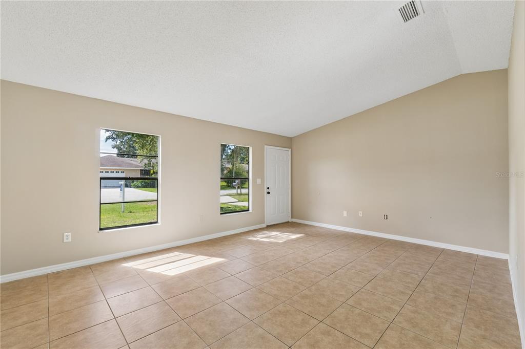 A dining area with tile floors, a pendant light, and sliding doors leading to a backyard — 648 FLORIDIAN DRIVE, KISSIMMEE, FL