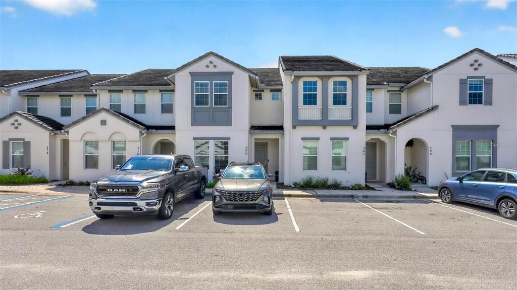 A white front door stands next to a staircase with white balusters in a foyer — 306 CAPTIVA DRIVE, DAVENPORT, FL
