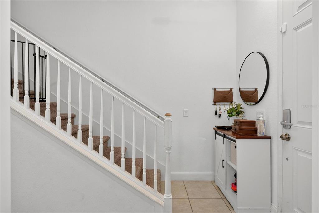 A kitchen features white cabinets, black countertops, a large island with bar seating, and tile flooring — 306 CAPTIVA DRIVE, DAVENPORT, FL