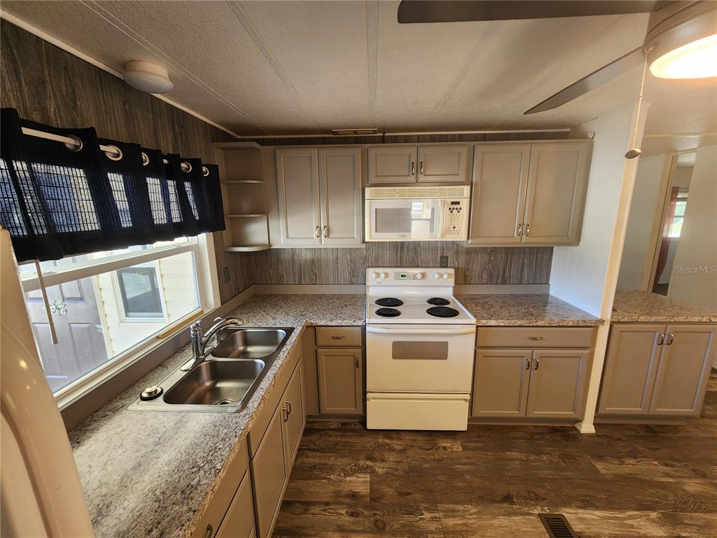 A kitchen with gray cabinets, a white stove, and granite-look countertops — 808 53RD AVENUE E UNIT 191, BRADENTON, FL