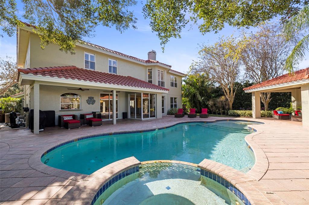 A two-story house with a tiled roof, swimming pool, spa, and covered patio area — 4165 MORENO DRIVE, PALM HARBOR, FL
