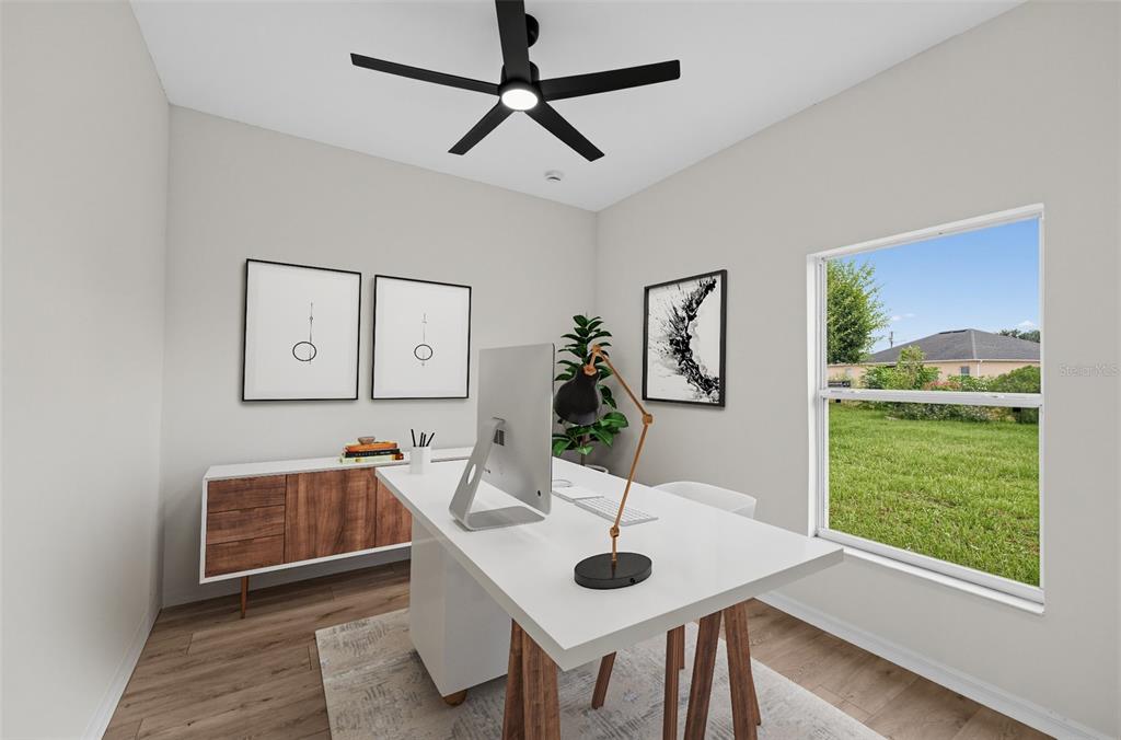 A home office features a white desk, a wooden sideboard, and a window overlooking grass — 507 BRITTEN DRIVE, KISSIMMEE, FL