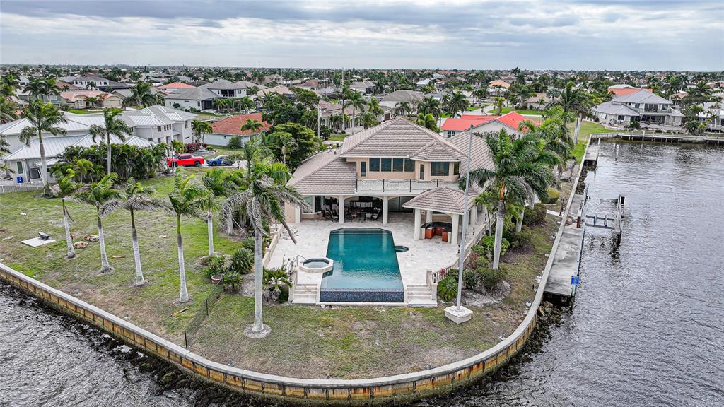 An aerial view shows a waterfront house with a pool, patio, and palm trees — 3 HIBISCUS DRIVE, PUNTA GORDA, FL