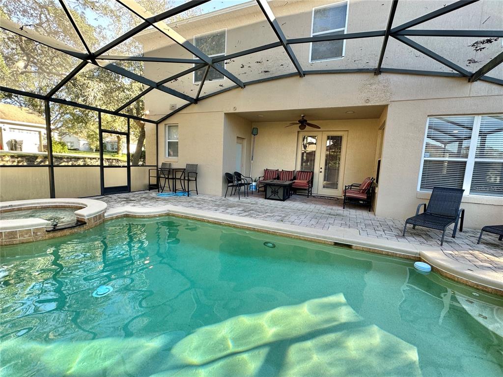 A screened-in patio features a swimming pool, a hot tub, and outdoor seating furniture — 4410 PINE GOLD AVENUE, APOPKA, FL
