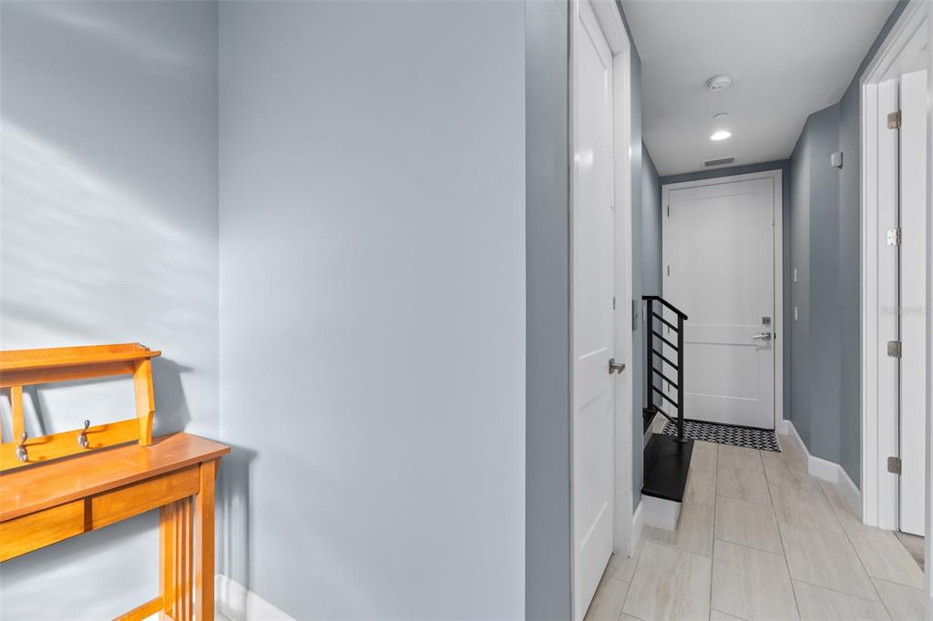 A kitchen features white cabinetry, a large central island, and blue walls — 129 S PARK AVENUE UNIT 8E, WINTER GARDEN, FL