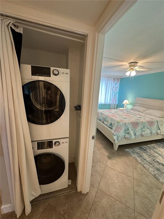 A stacked washer and dryer unit is located in a closet next to a bedroom — 9495 BLIND PASS ROAD UNIT 504, ST PETE BEACH, FL