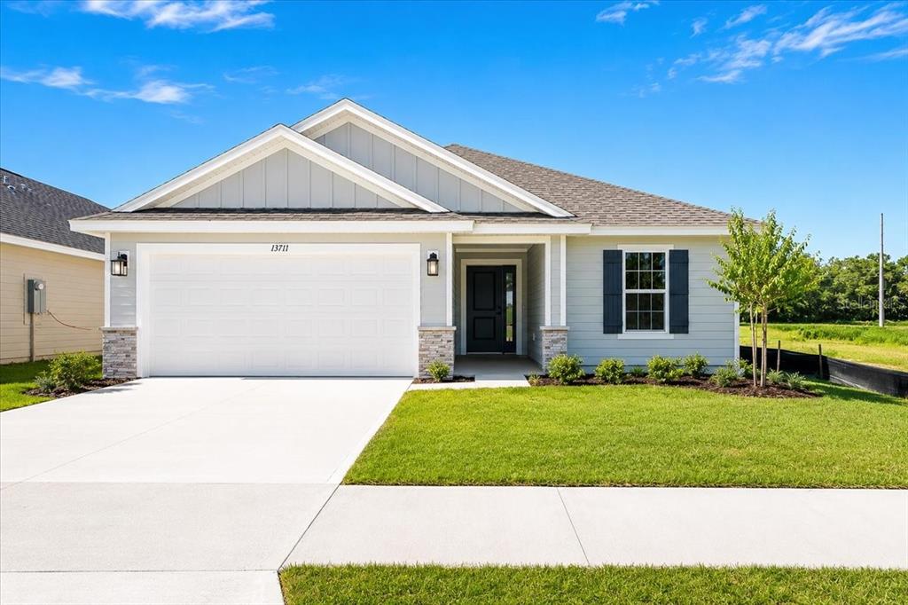 A single-story house with light gray siding, a two-car garage, and a front porch — 2585 SW 250TH DRIVE, NEWBERRY, FL