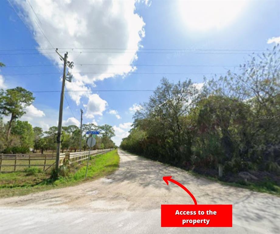 A dirt road leads past a wooden fence and trees toward a property entrance — 13649 & 13601 MURCOTT AVENUE, CLEWISTON, FL