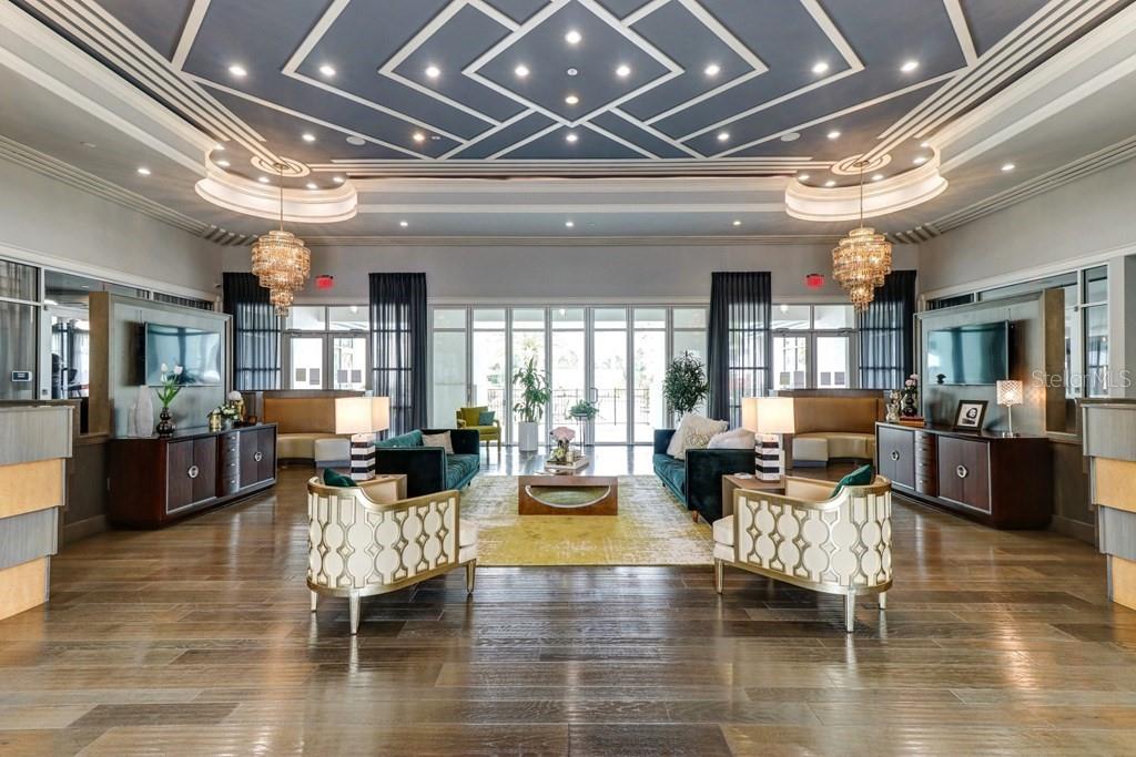 A symmetrical lobby features a geometric ceiling, two crystal chandeliers, and matching seating areas — 1688 CELEBRATION BOULEVARD UNIT The Audrey, CELEBRATION, FL