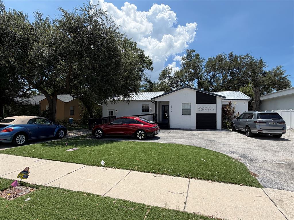 A white single-story building with a black accent wall and three parked cars in front — 3714 W HORATIO STREET, TAMPA, FL
