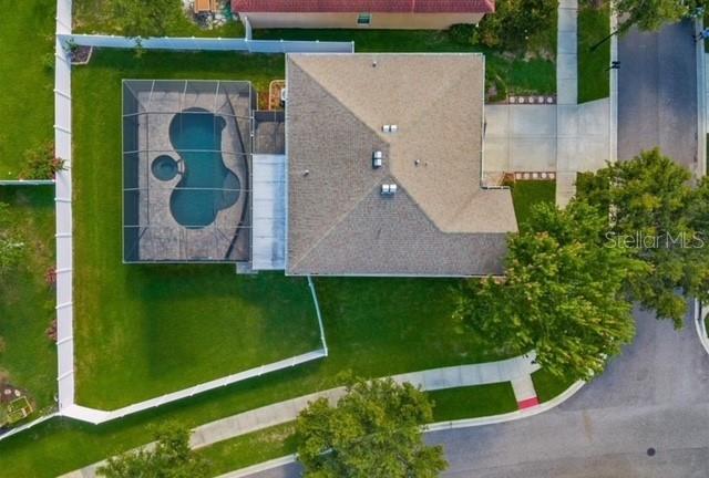 An aerial view shows a house with a screened-in pool and a fenced backyard — 2863 MAPLE BROOK LOOP, LUTZ, FL