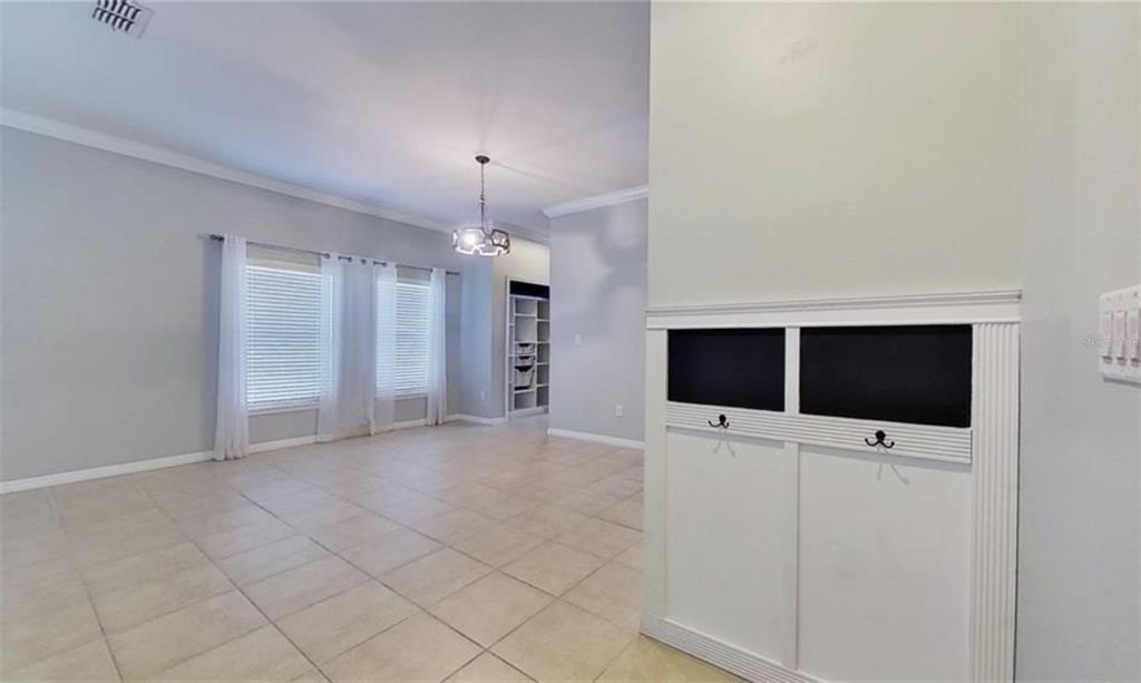 An interior view of a room with tile flooring, large windows, and a built-in mudroom bench — 2863 MAPLE BROOK LOOP, LUTZ, FL