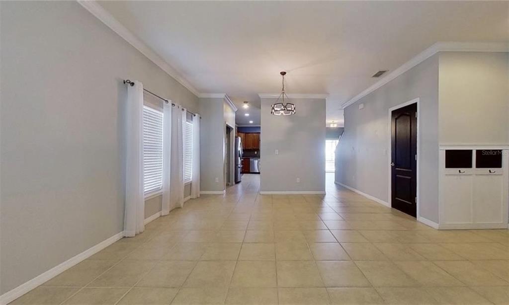 A dining area with tile flooring, a chandelier, and a view into the kitchen — 2863 MAPLE BROOK LOOP, LUTZ, FL