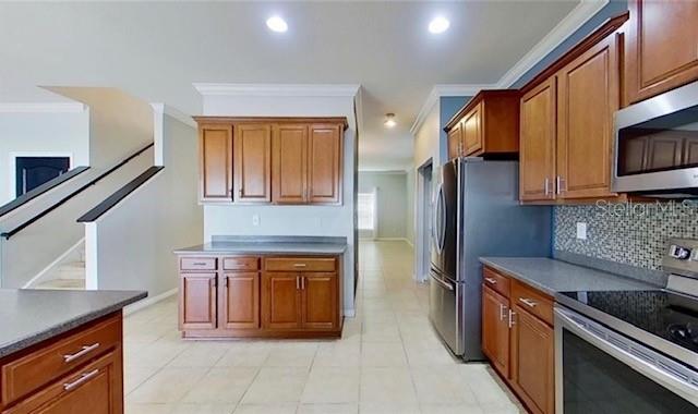A kitchen features wood cabinets, stainless steel appliances, and tile flooring — 2863 MAPLE BROOK LOOP, LUTZ, FL