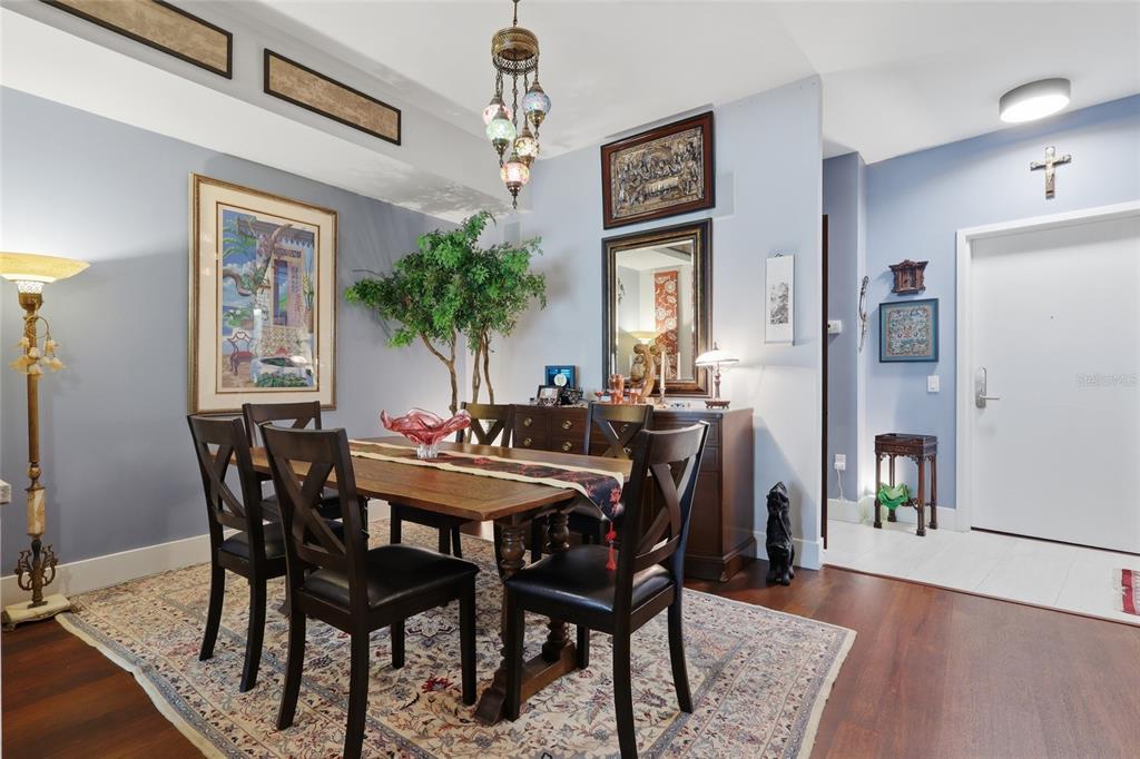 A dining room features a wooden table, dark chairs, a patterned rug, and wall art — 111 N 12TH STREET UNIT 1521, TAMPA, FL