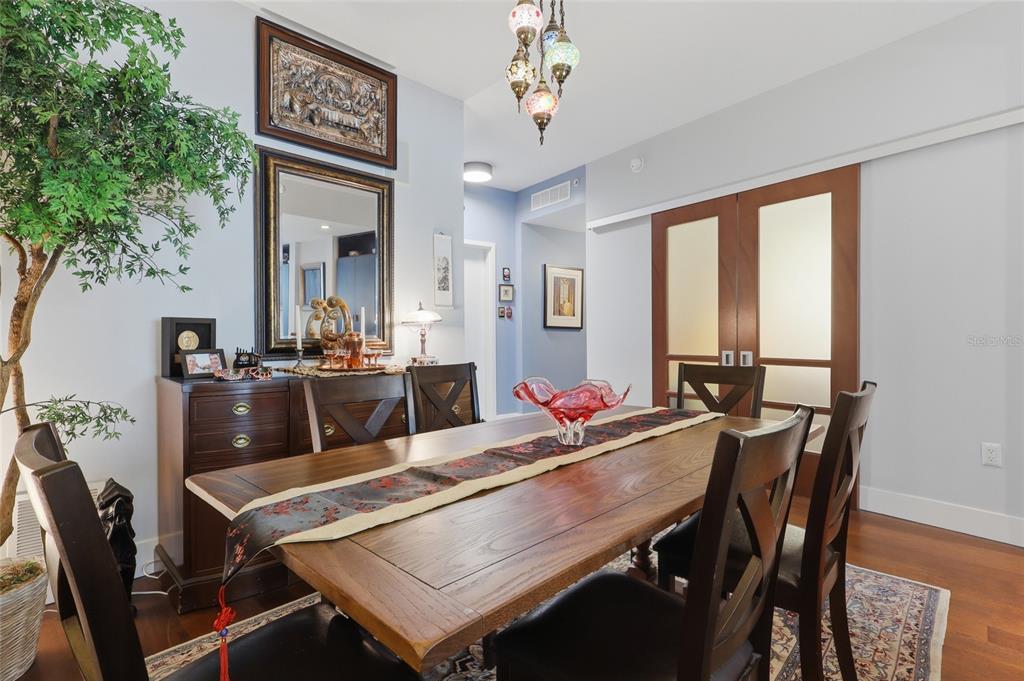 A dining room features a wooden table, chairs, a sideboard, and a decorative hanging light — 111 N 12TH STREET UNIT 1521, TAMPA, FL