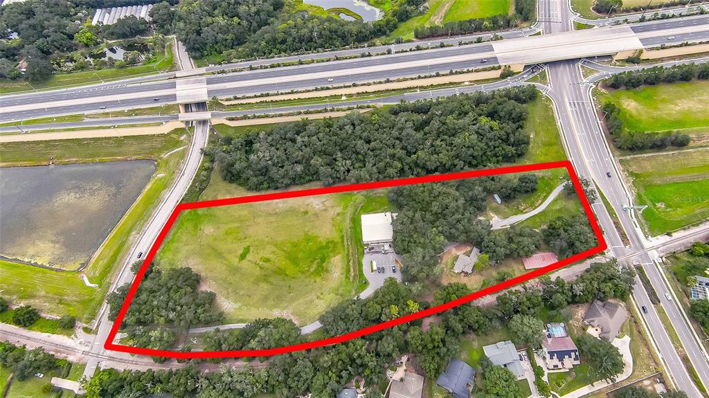 This aerial view shows a large, partially wooded plot of land outlined in red — 6837 LAKEVILLE ROAD, APOPKA, FL