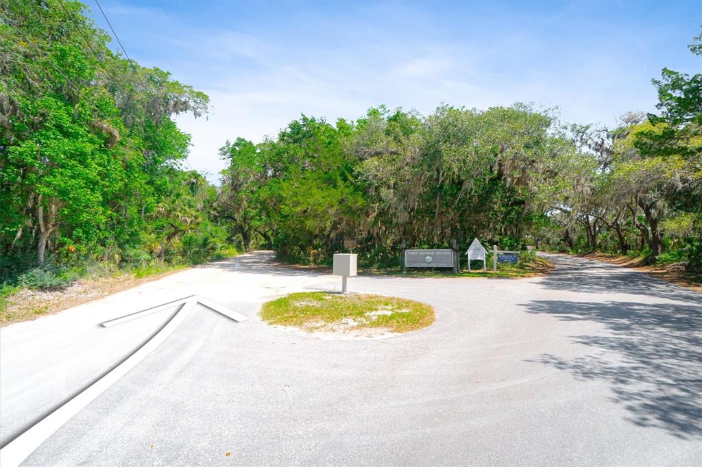 A paved road forks around a small grassy island with a sign in a wooded area — 10474 SALT MARSH TRAIL, JACKSONVILLE, FL