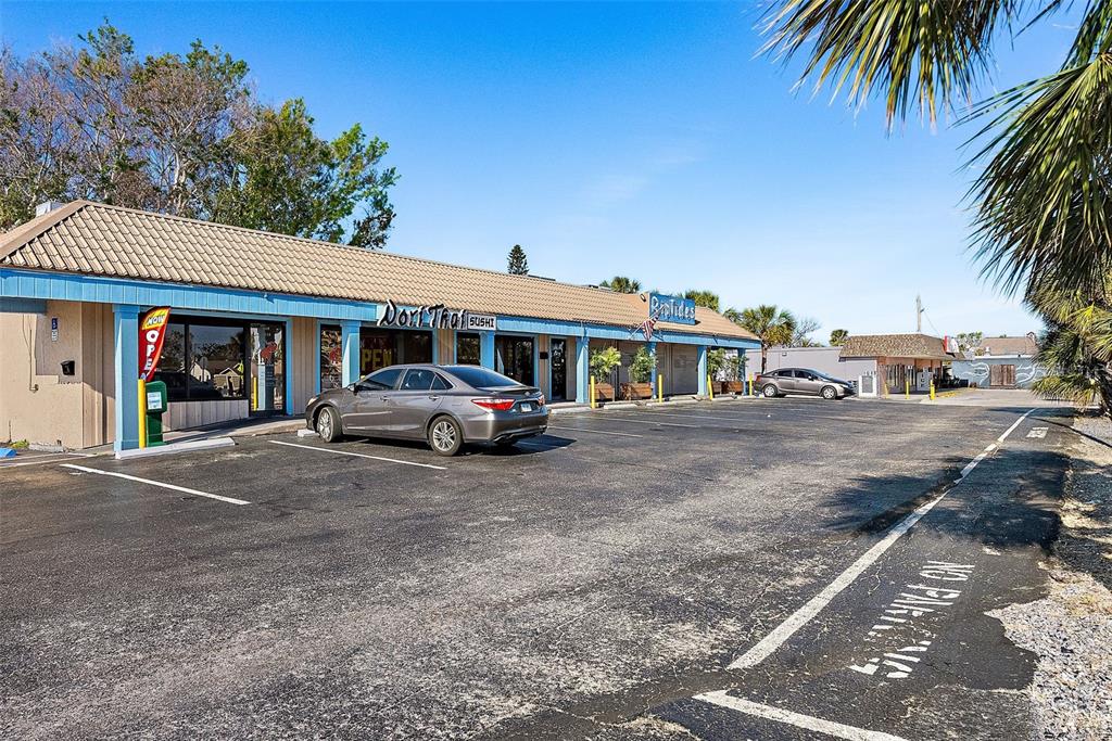 A single-story commercial strip mall with a parking lot and two visible storefronts — 7612 BLIND PASS ROAD, ST PETE BEACH, FL