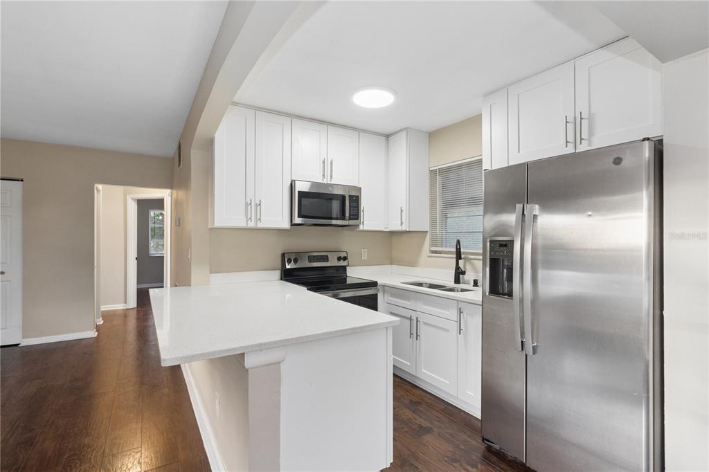 A kitchen with white cabinets, stainless steel appliances, a double sink, and a window — 7045 FIRESIDE STREET, SPRING HILL, FL