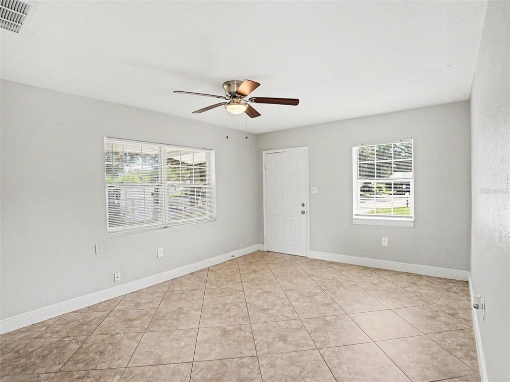 A kitchen features granite countertops, white cabinets, stainless steel appliances, and a tiled backsplash — 4514 DREXEL AVENUE, ORLANDO, FL