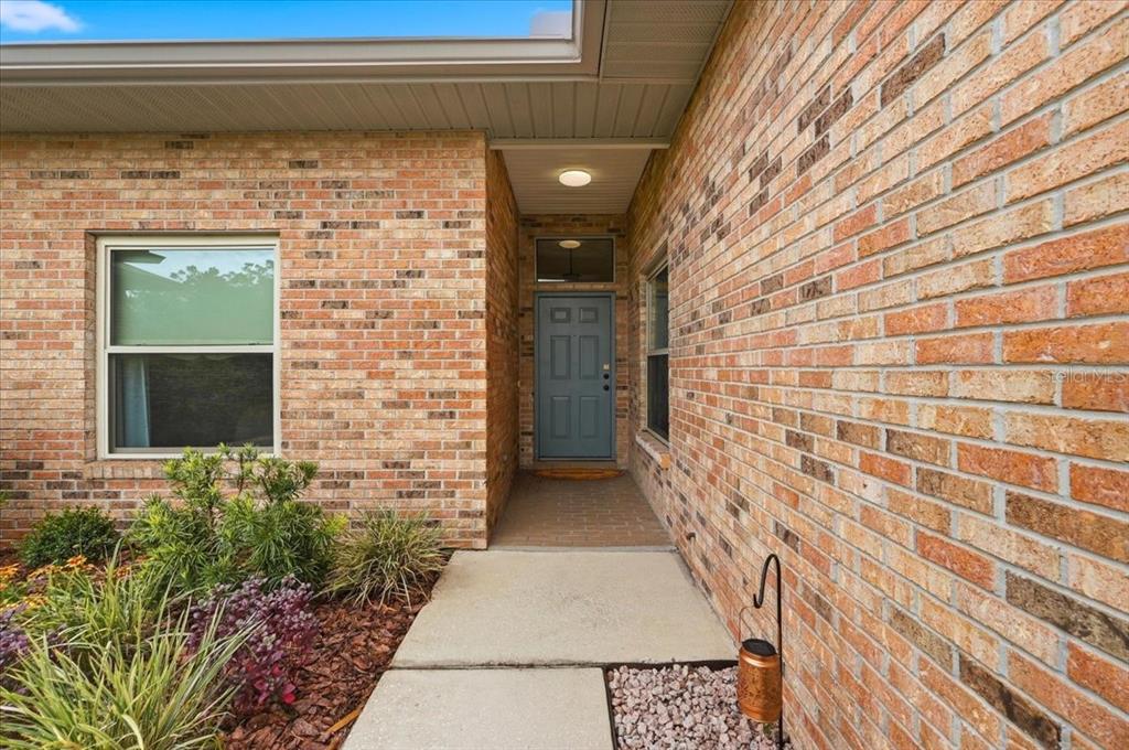 A single-story brick house with a two-car garage and a concrete driveway — 730 MARTINIQUE CIRCLE, LAKELAND, FL