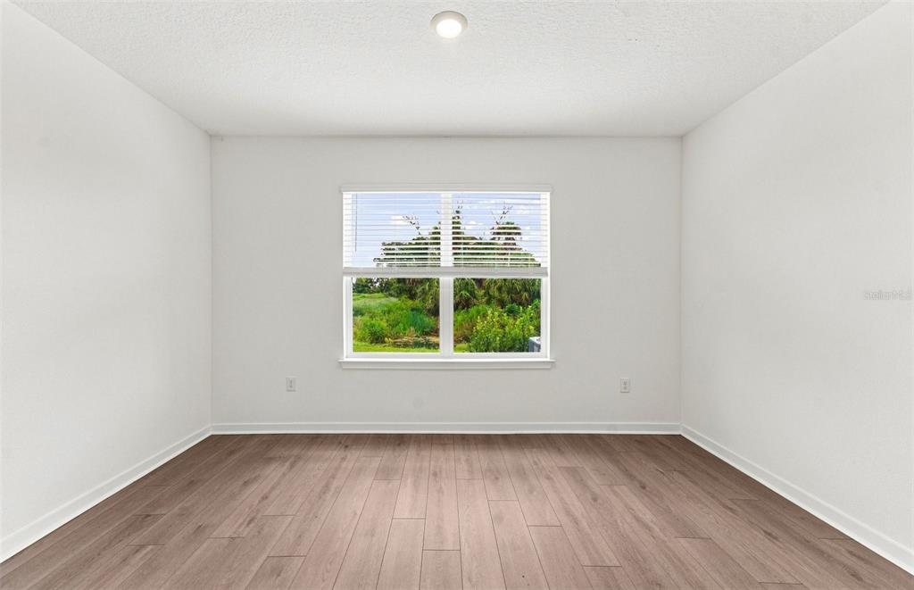 A kitchen with dark cabinets, a white island, stainless steel appliances, and tile flooring — 9877 TRELLIS VINE WAY, PARRISH, FL