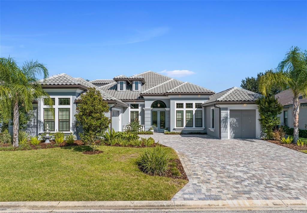 A single-story house with a gray exterior, tiled roof, and a paved driveway — 534 WINGSPAN DRIVE, ORMOND BEACH, FL