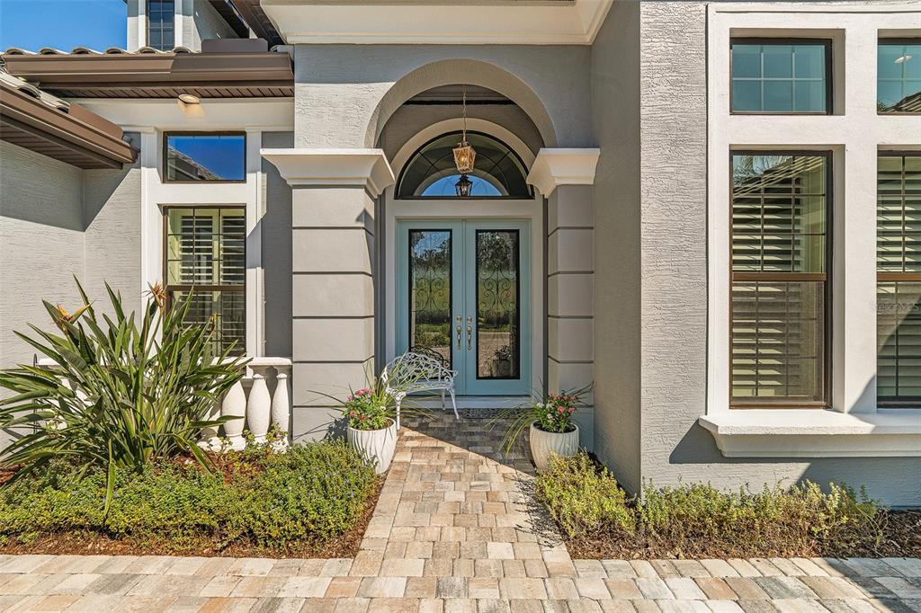 A paved walkway leads to the light blue double front doors of a gray house — 534 WINGSPAN DRIVE, ORMOND BEACH, FL