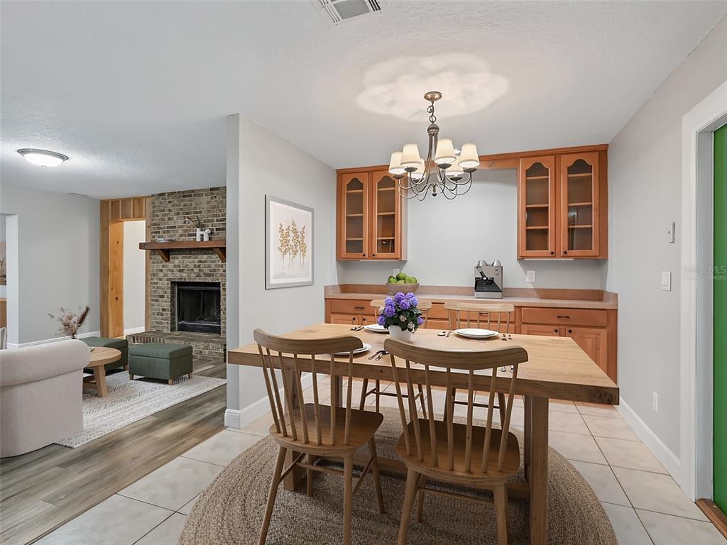 A kitchen features wood cabinets, stainless steel appliances, and light-colored tile flooring — 8234 S US 301, BUSHNELL, FL